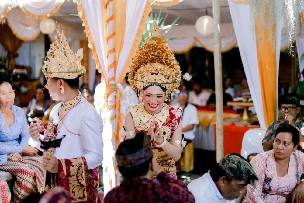 Balinese weddings Traditional Indonesian Wedding Couple in traditional Balinese wedding attire with gold headpieces at a temple ceremony