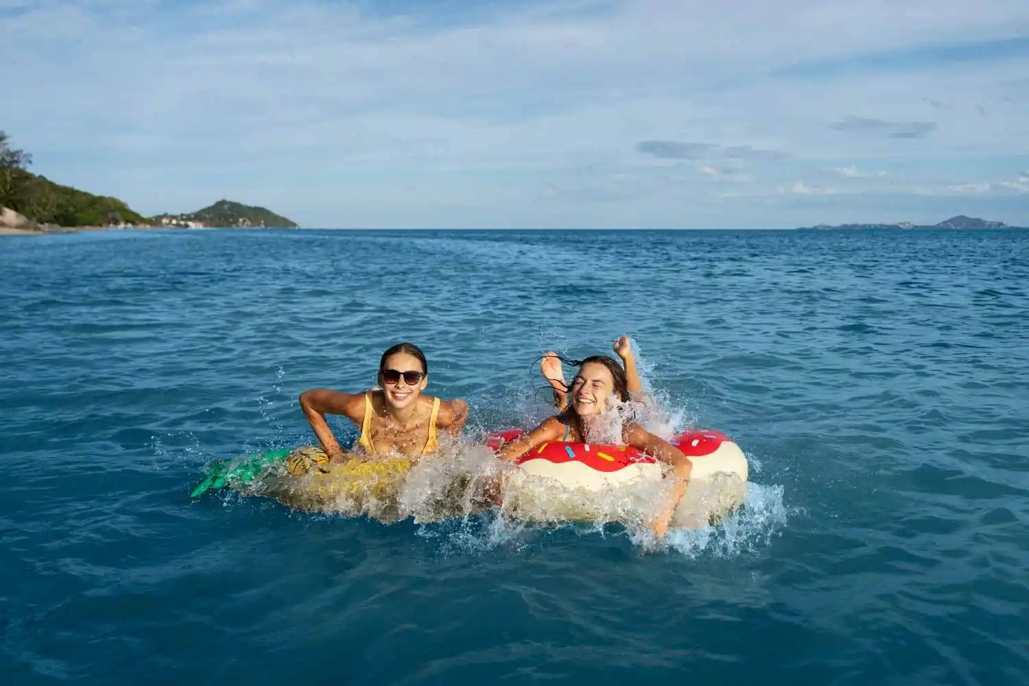 Two women swimming at a calm beach in Bali, one of the best beaches in Bali for swimming